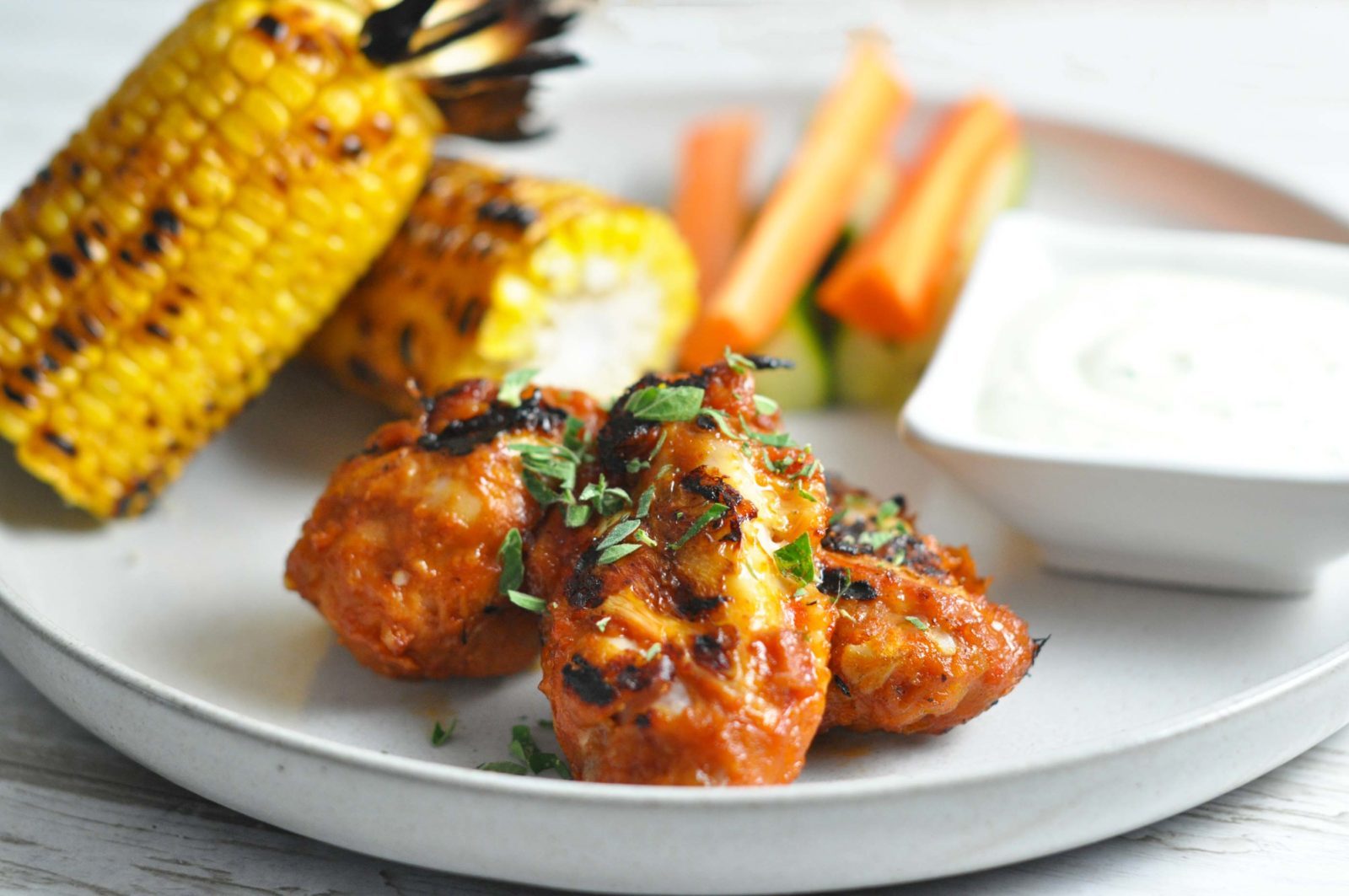Chicken wings with corn on the cob and snack veggies