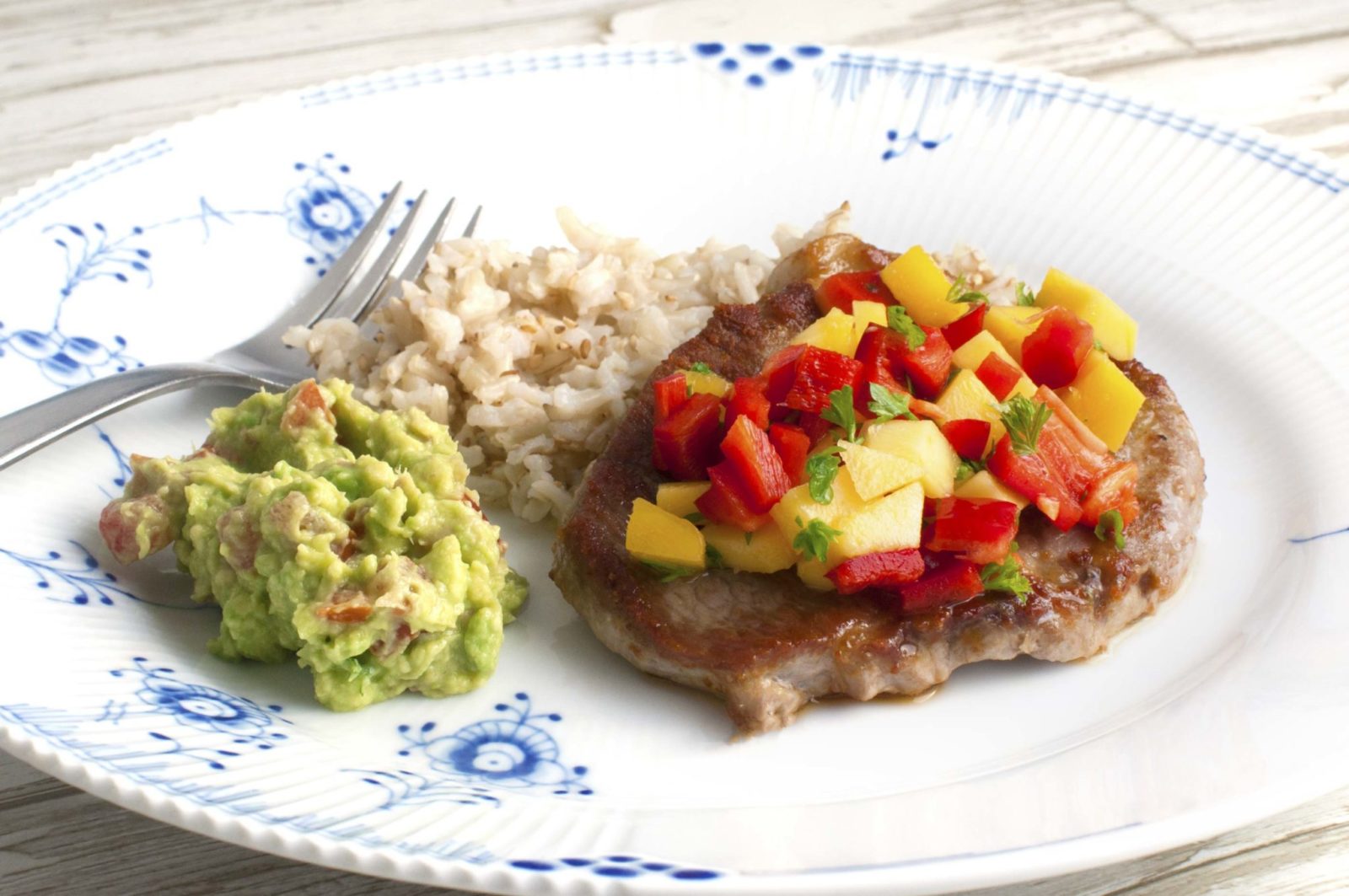 Juicy pork chops with mango salsa and guacamole
