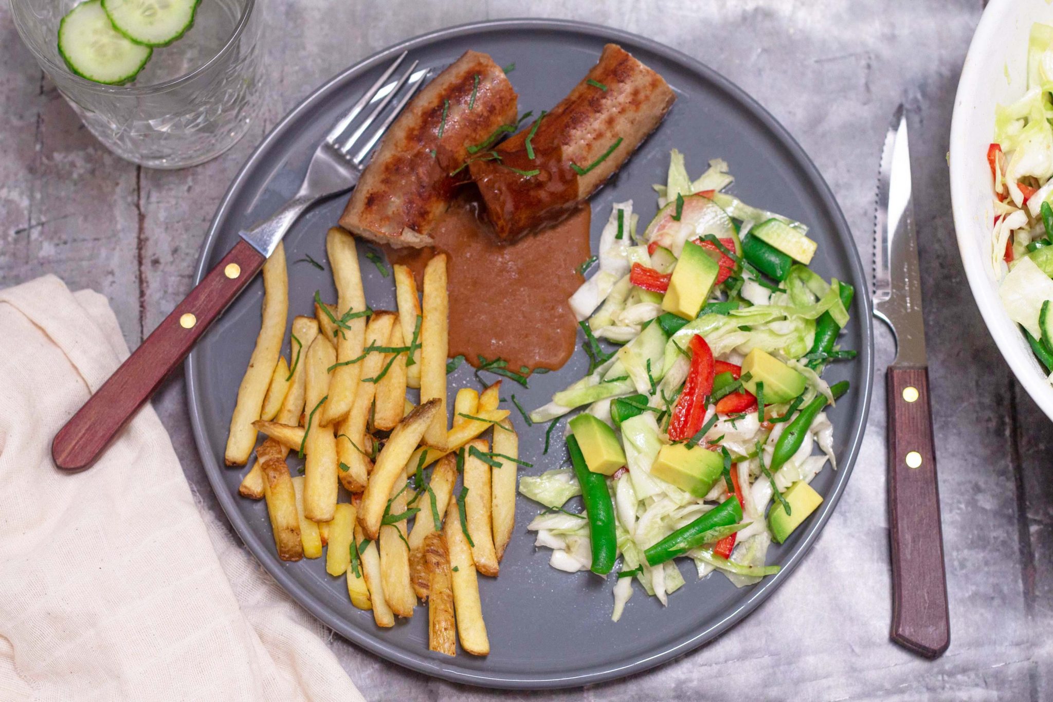 Dinner sausage with chips, gravy and a quick salad