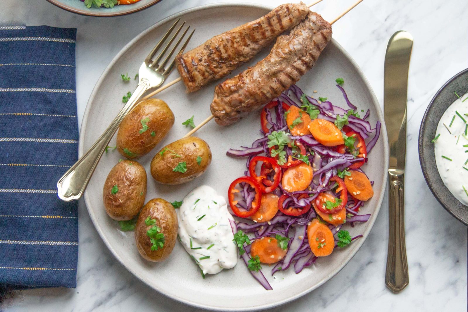 Pork tenderloin skewers with potatoes, salad and aioli