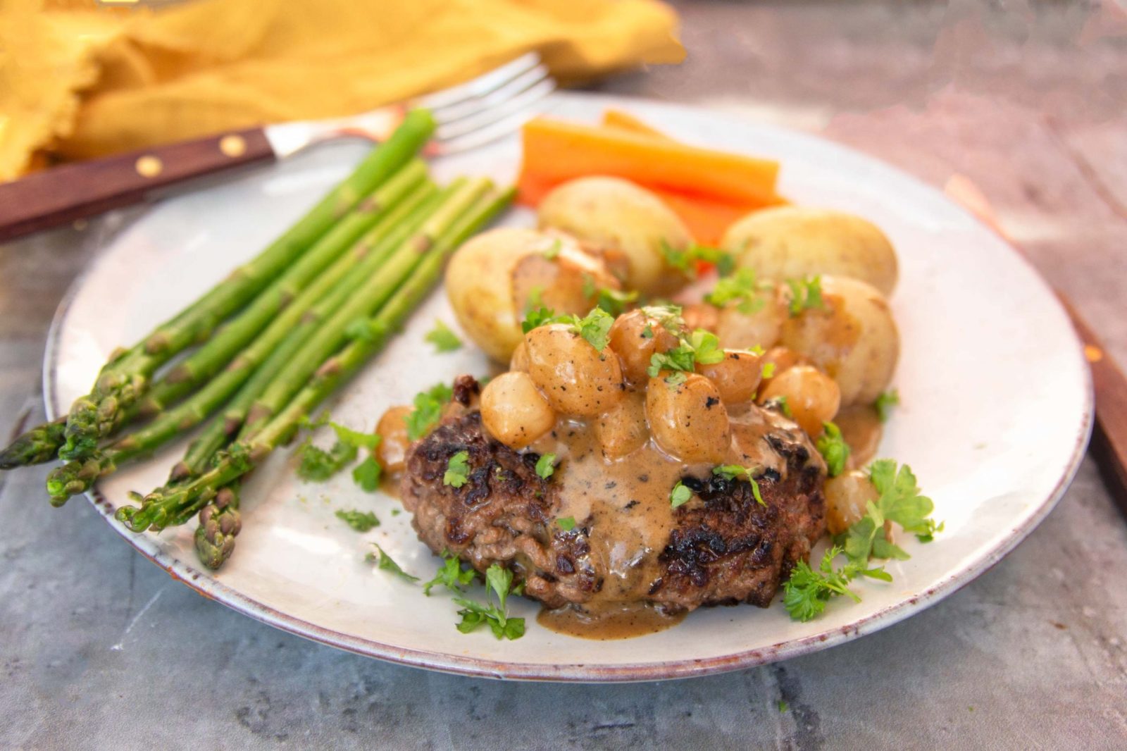 Mince steaks with silverskin onions, potatoes and asparagus
