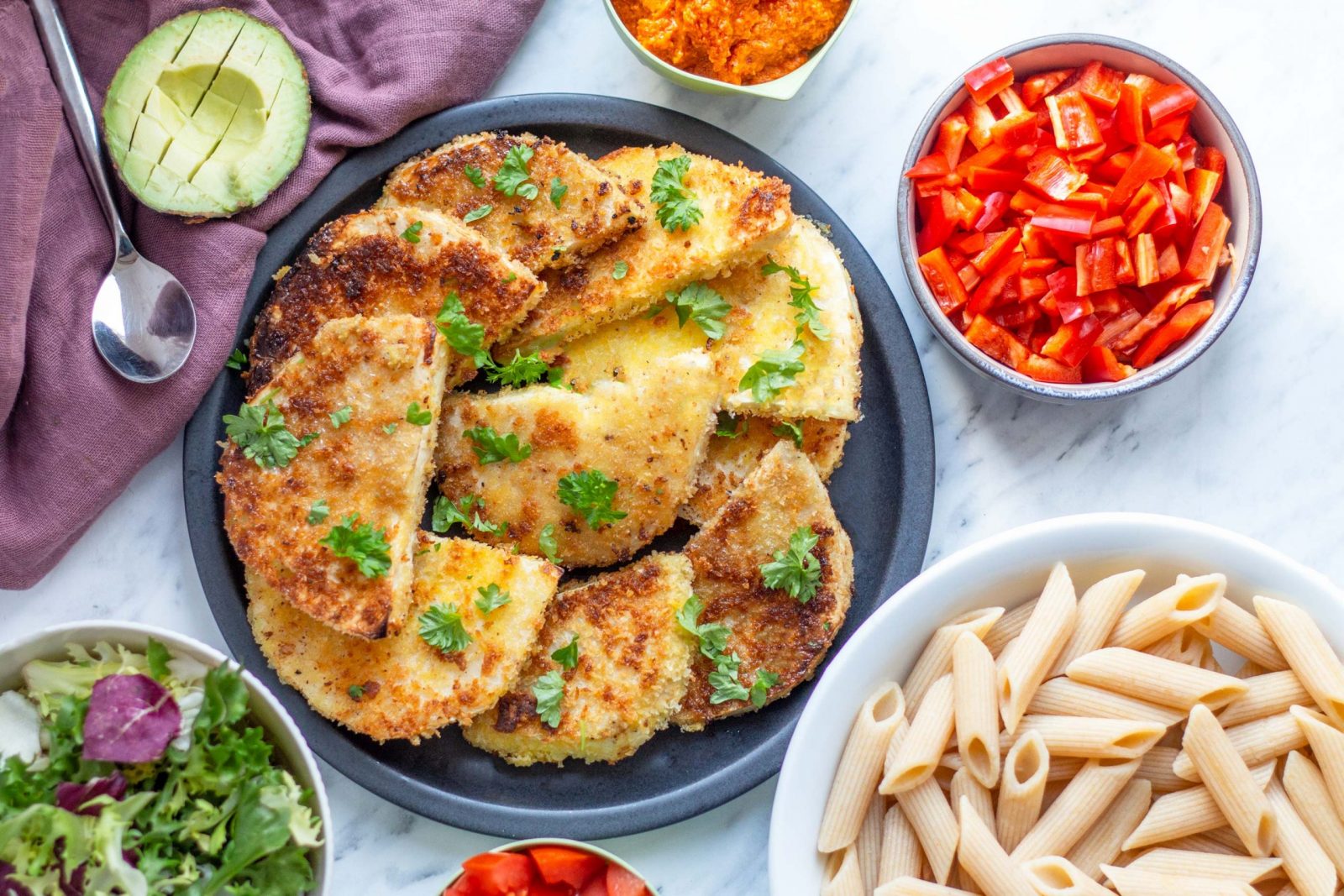 Breaded veggie steaks with pasta salad and yellow pesto